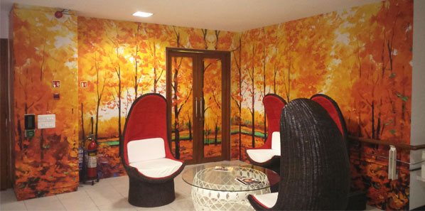 Autumn-forest wall mural wrapping an EdgeVerve breakout lounge with egg chairs.